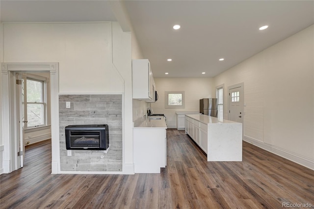 kitchen featuring heating unit, white cabinets, freestanding refrigerator, and a sink