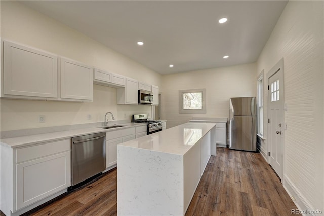 kitchen featuring dark wood finished floors, stainless steel appliances, light countertops, and a sink