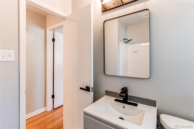 1170 Kingston St, Aurora, CO 80010 - bathroom with toilet, vanity, and wood finished floors