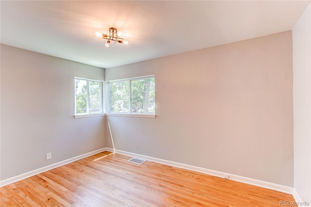 1170 Kingston St, Aurora, CO 80010 - unfurnished room featuring baseboards, a chandelier, and light wood-type flooring