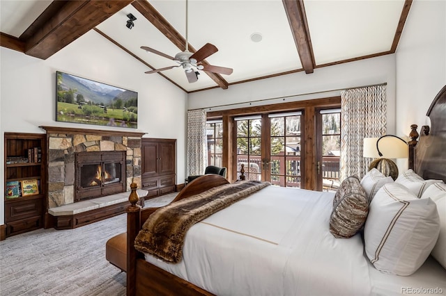 bedroom with lofted ceiling with beams, french doors, a stone fireplace, and ceiling fan