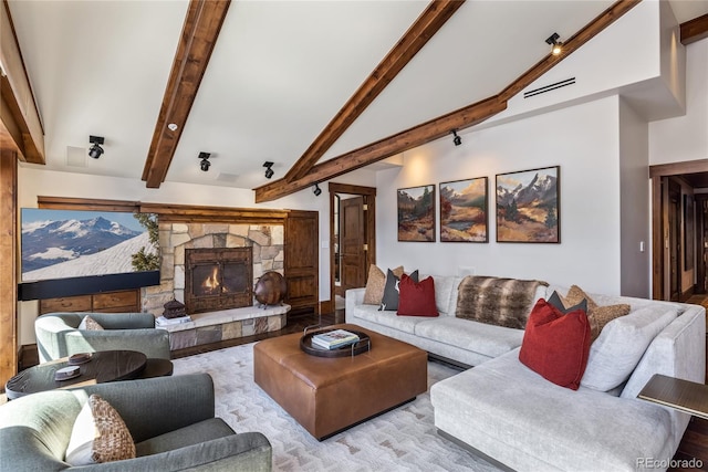 living room with a fireplace, wood finished floors, and vaulted ceiling with beams