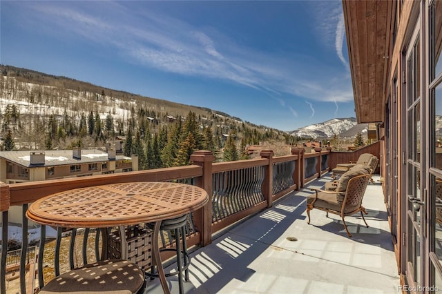 snow covered back of property featuring a mountain view