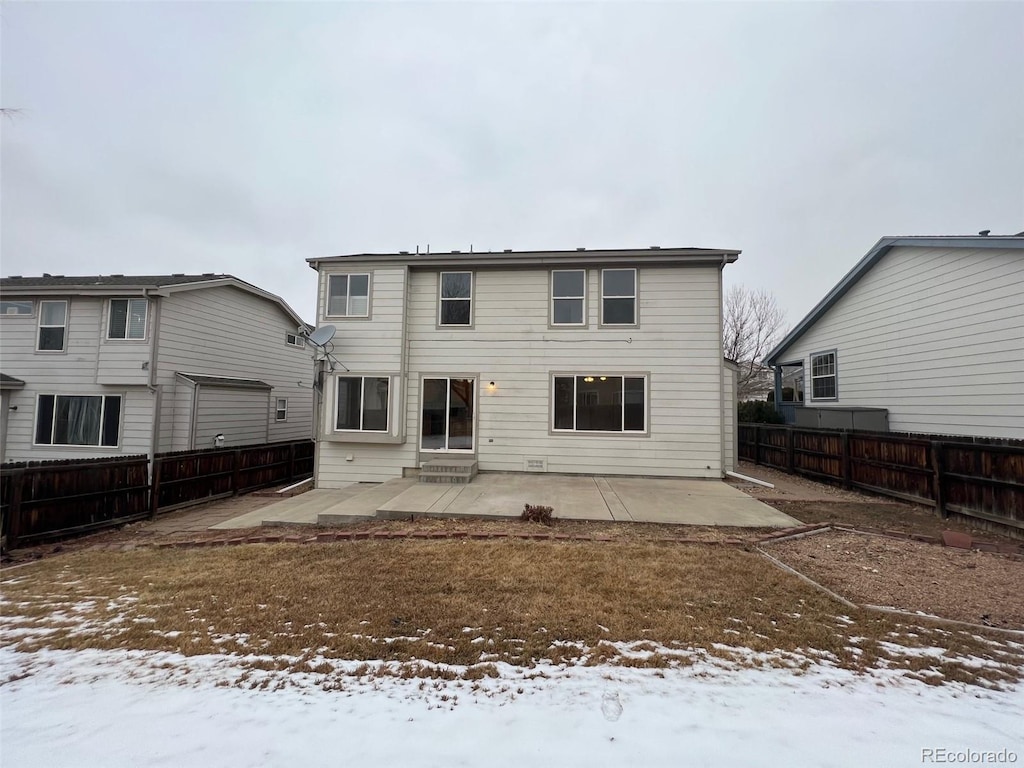 snow covered house featuring a patio