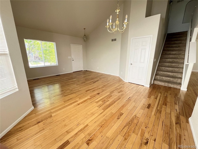20558 E Grand Ln, Aurora, CO 80015 - unfurnished room with light wood-style floors, stairway, a chandelier, baseboards, and high vaulted ceiling