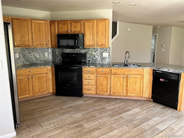 20558 E Grand Ln, Aurora, CO 80015 - kitchen with black appliances, a sink, light wood finished floors, and decorative backsplash