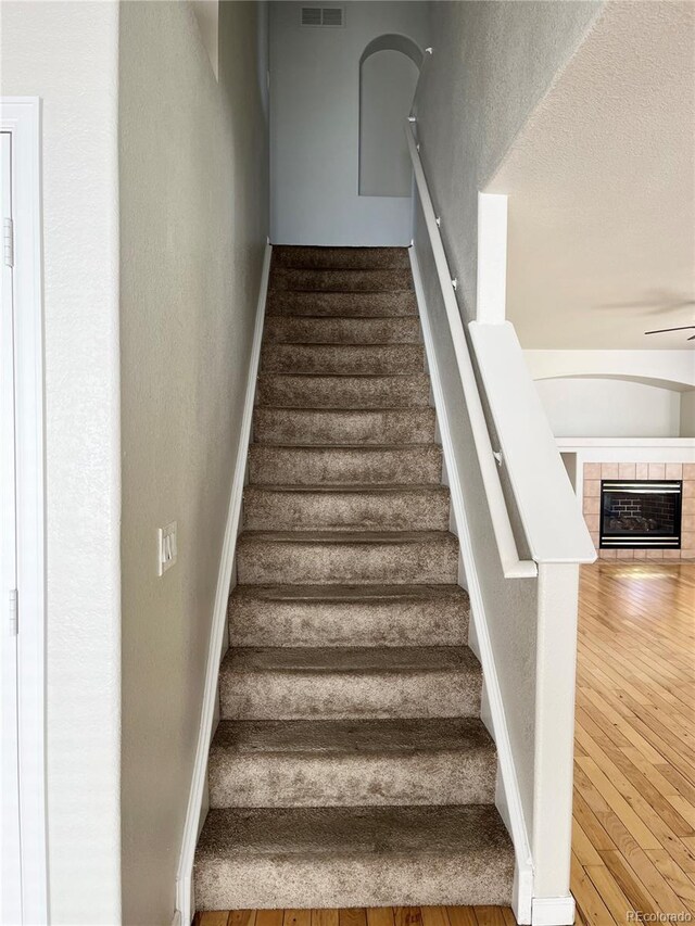 20558 E Grand Ln, Aurora, CO 80015 - stairway featuring wood-type flooring, baseboards, a ceiling fan, and a tile fireplace