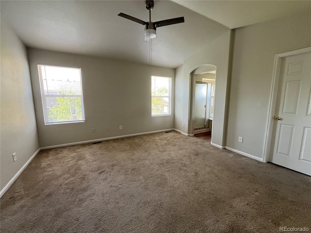 20558 E Grand Ln, Aurora, CO 80015 - unfurnished bedroom featuring arched walkways, carpet, baseboards, vaulted ceiling, and ceiling fan