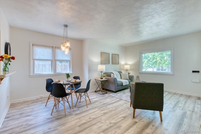 2684 S Logan St, Denver, CO 80210 - dining area with healthy amount of natural light, light wood-style floors, baseboards, a chandelier, and a textured ceiling