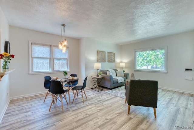 2684 S Logan St, Denver, CO 80210 - dining area featuring a textured ceiling, plenty of natural light, light wood-style floors, and baseboards