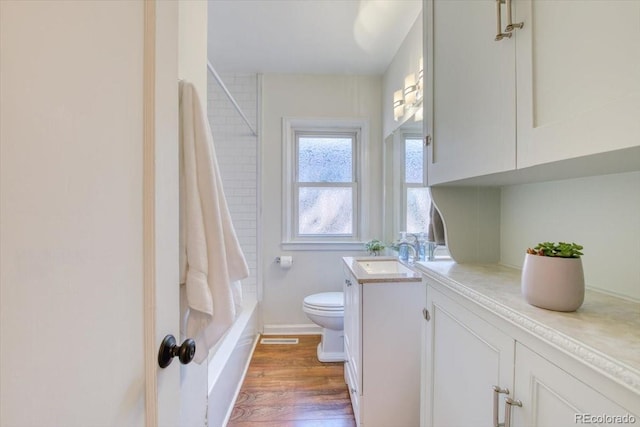 2684 S Logan St, Denver, CO 80210 - bathroom featuring toilet, vanity, wood finished floors, shower / tub combo, and baseboards