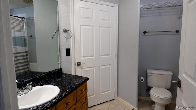 full bathroom with toilet, a shower with shower curtain, vanity, baseboards, and tile patterned floors