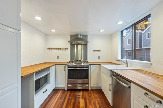 kitchen featuring white cabinets, appliances with stainless steel finishes, dark hardwood / wood-style flooring, and wooden counters