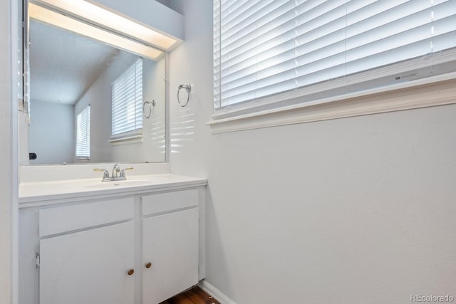 bathroom with vanity, wood-type flooring, and a textured ceiling