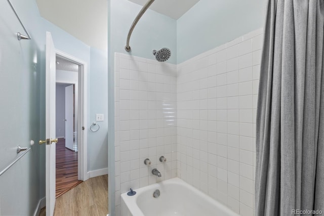 bathroom with hardwood / wood-style floors and shower / bathtub combination with curtain