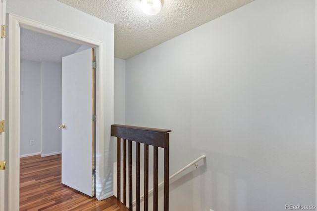 hallway featuring dark wood-type flooring and a textured ceiling