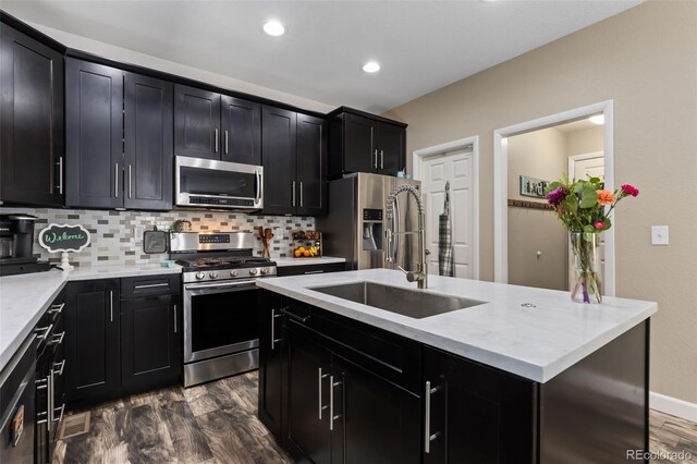 139 N Prairie Falcon Pkwy, Brighton, CO 80601 - kitchen with stainless steel appliances, dark cabinetry, a sink, dark wood-type flooring, and recessed lighting