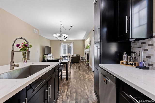 139 N Prairie Falcon Pkwy, Brighton, CO 80601 - kitchen with a sink, dark cabinetry, dishwasher, and a chandelier