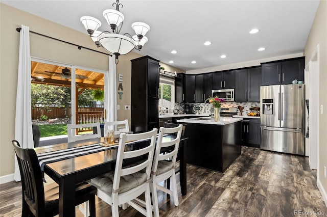 139 N Prairie Falcon Pkwy, Brighton, CO 80601 - kitchen featuring stainless steel appliances, dark cabinets, light countertops, dark wood-style floors, and backsplash