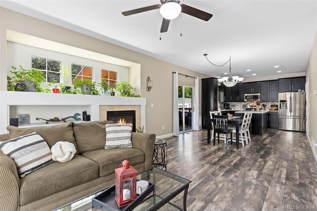 139 N Prairie Falcon Pkwy, Brighton, CO 80601 - living room featuring healthy amount of natural light, a chandelier, baseboards, dark wood-style flooring, and recessed lighting