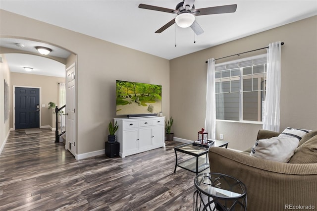 139 N Prairie Falcon Pkwy, Brighton, CO 80601 - living area featuring dark wood-type flooring, arched walkways, a ceiling fan, baseboards, and plenty of natural light