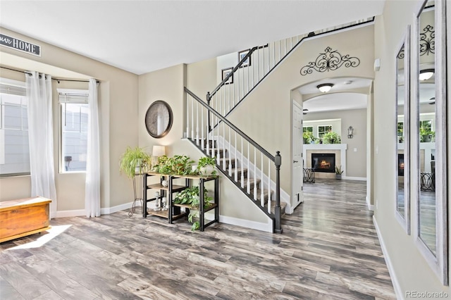 139 N Prairie Falcon Pkwy, Brighton, CO 80601 - entrance foyer with wood finished floors, stairway, baseboards, and a glass covered fireplace