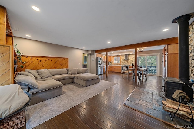 living room with recessed lighting, a wood stove, and dark wood-style flooring