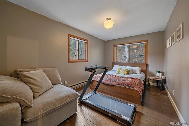 bedroom with baseboards, multiple windows, and wood finished floors
