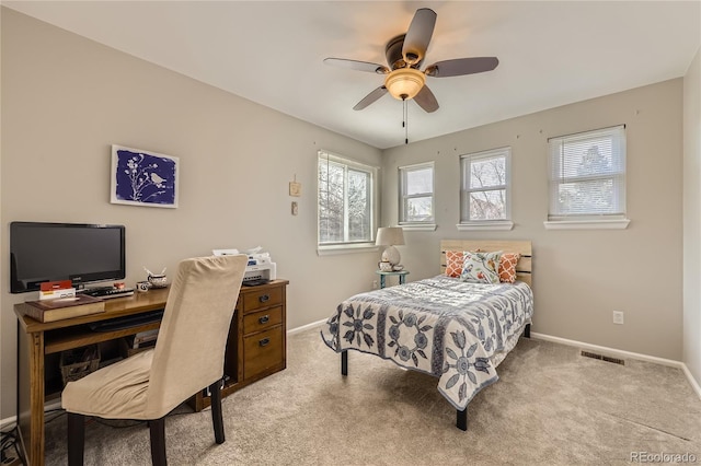 carpeted bedroom featuring baseboards, ceiling fan, and visible vents