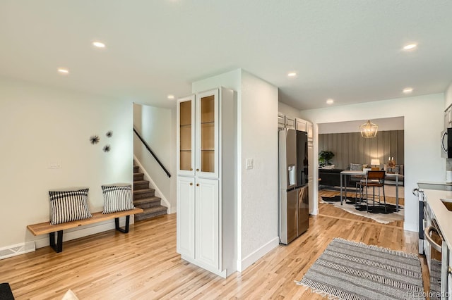 kitchen featuring white cabinetry, stainless steel fridge, and light wood-type flooring