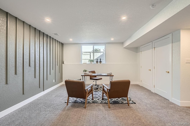 carpeted office featuring a textured ceiling