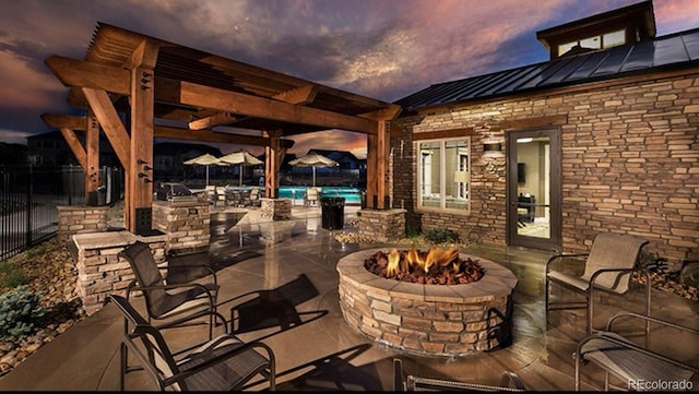 14589 Hagus Pl, Parker, CO 80134 - patio terrace at dusk featuring a fire pit, a patio, an outdoor kitchen, and a pergola