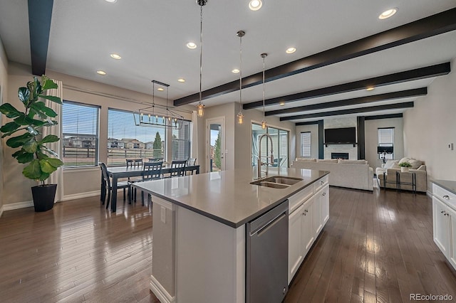 14589 Hagus Pl, Parker, CO 80134 - kitchen featuring stainless steel dishwasher, a sink, white cabinets, dark wood-style flooring, and baseboards