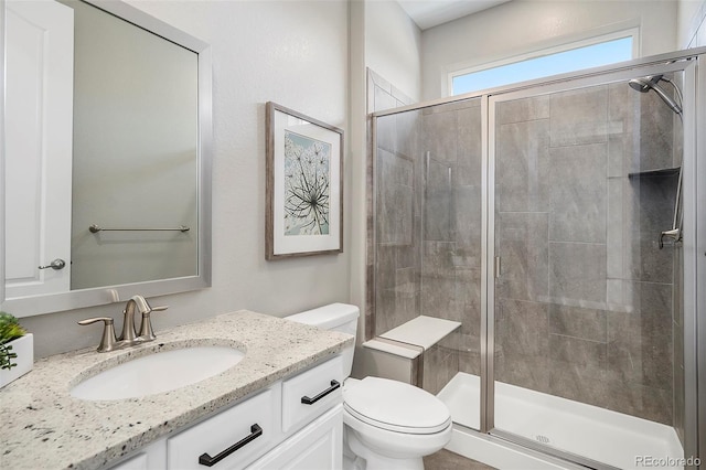 full bath featuring vanity, toilet, and a stall shower