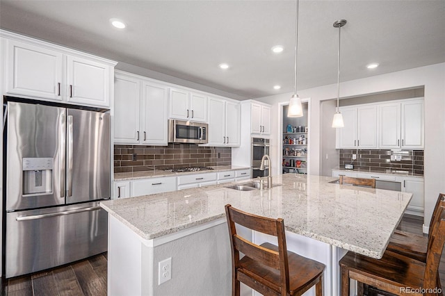 kitchen with dark wood-style flooring, appliances with stainless steel finishes, white cabinetry, and a sink