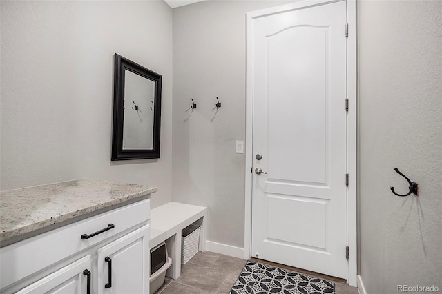 mudroom with light tile patterned floors and baseboards