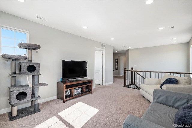 living room with recessed lighting, light colored carpet, visible vents, and baseboards