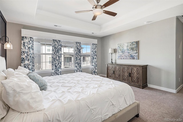 carpeted bedroom featuring a ceiling fan, a tray ceiling, crown molding, and baseboards