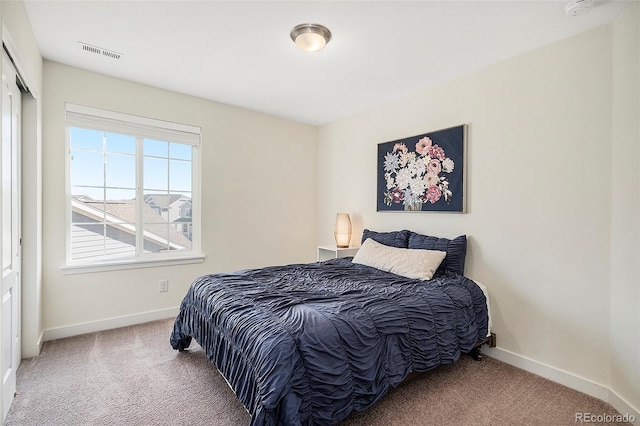 carpeted bedroom featuring visible vents, baseboards, and a closet