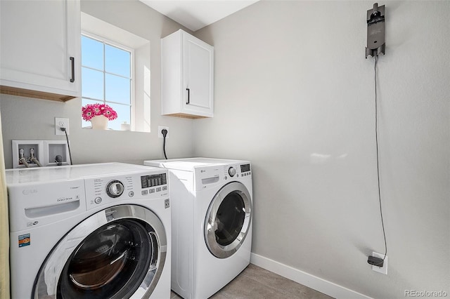 laundry area featuring baseboards, cabinet space, and washer and clothes dryer