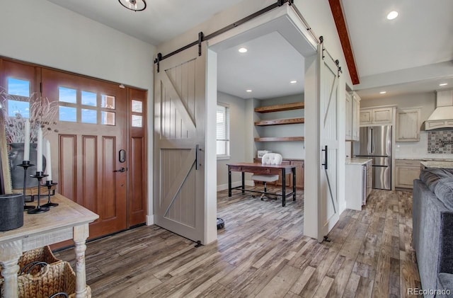 foyer entrance with a barn door and hardwood / wood-style flooring