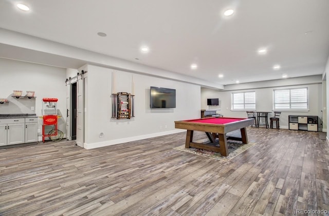 game room featuring pool table, a barn door, and hardwood / wood-style flooring