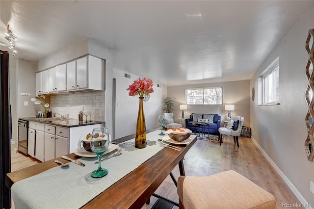 dining room featuring visible vents, light wood-style flooring, and baseboards