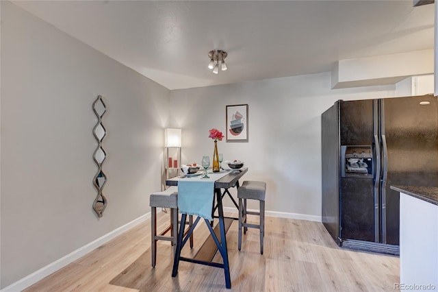 dining space with light wood finished floors and baseboards