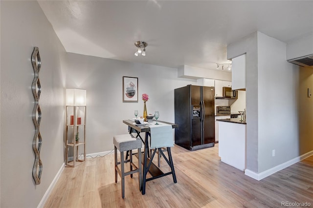 dining space featuring visible vents, light wood-style flooring, and baseboards