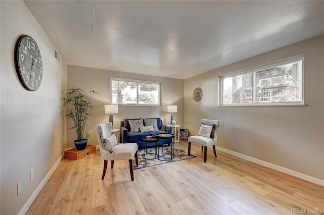 sitting room featuring light wood-type flooring, baseboards, and visible vents