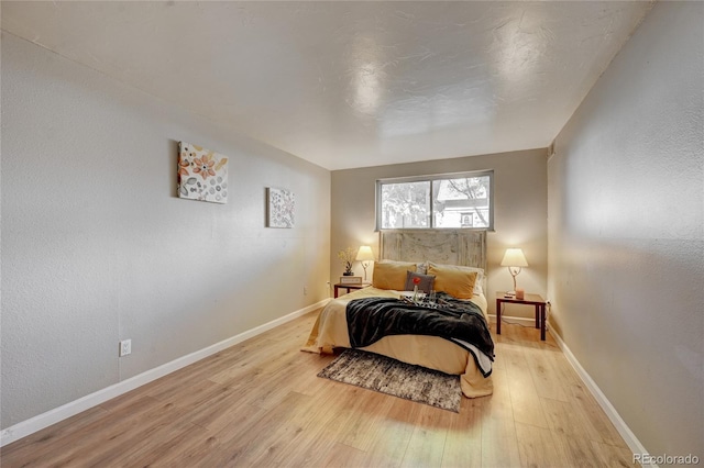 bedroom with light wood-style floors and baseboards