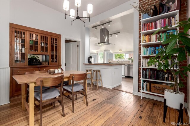 1776 S Logan St, Denver, CO 80210 - dining room featuring rail lighting, light wood finished floors, a chandelier, and high vaulted ceiling