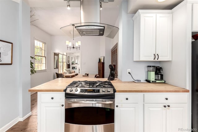 1776 S Logan St, Denver, CO 80210 - kitchen with stainless steel gas range, wood counters, island exhaust hood, a chandelier, and wood finished floors