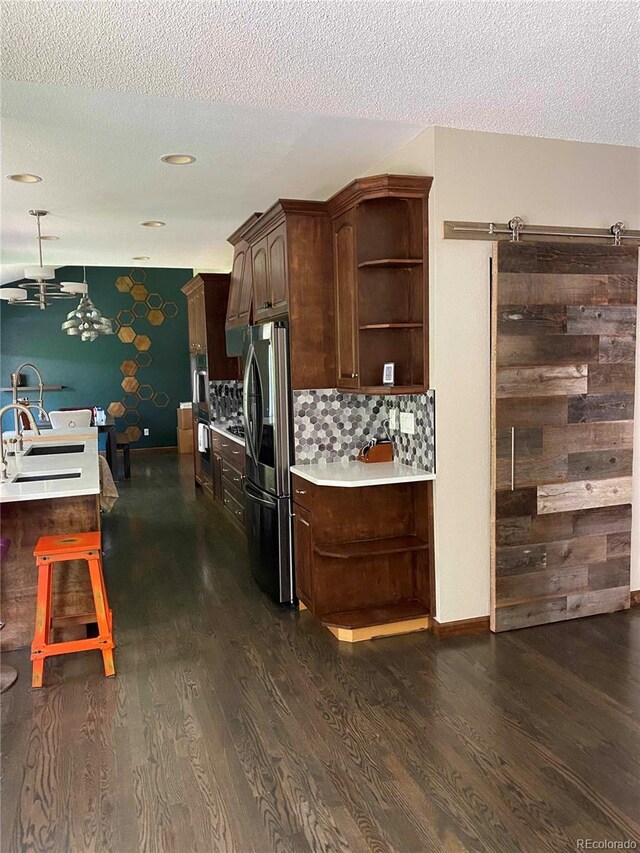 kitchen with stainless steel fridge with ice dispenser, open shelves, dark wood-style flooring, light countertops, and a sink